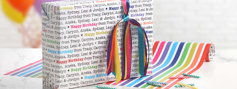 A package wrapped in custom printed birthday wrappng paper is shown with a colorful ribbon