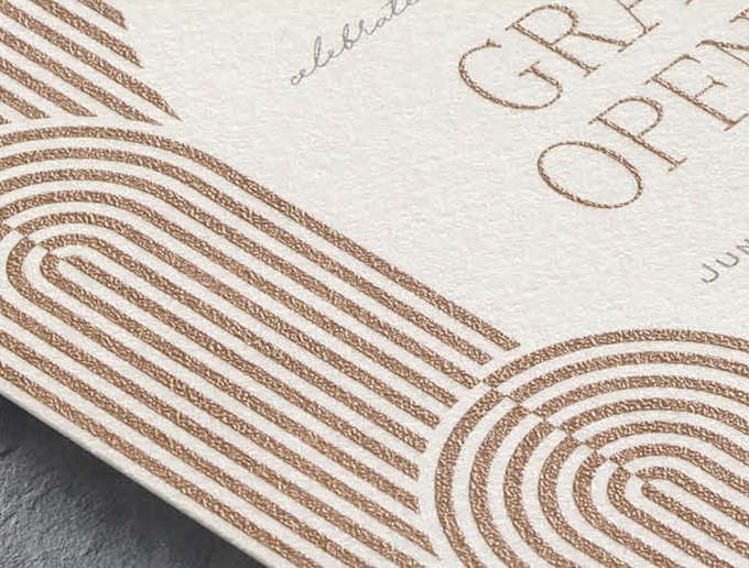Closeup image of a custom invitation with a modern arch design in copper thermography print