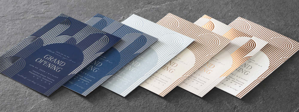 Six custom printed invitations fanned out featuring different specialty print processes