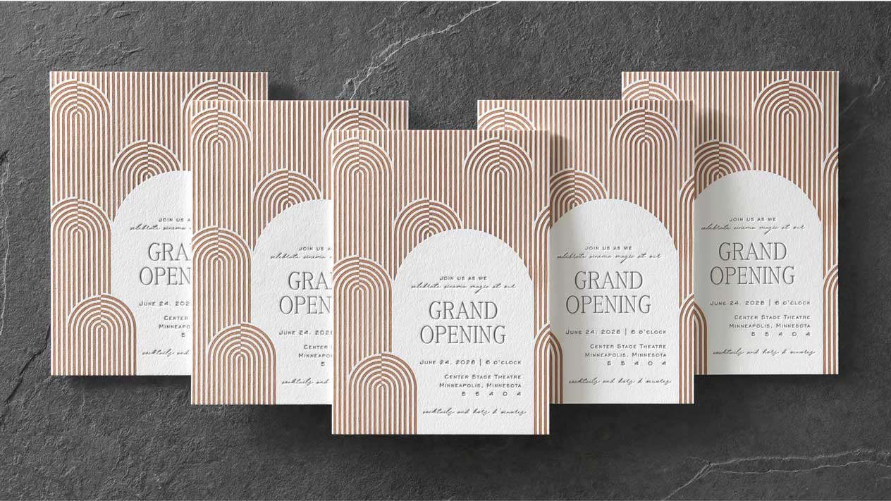 Five custom event invitations with copper letterpress printing stacked in a V formation