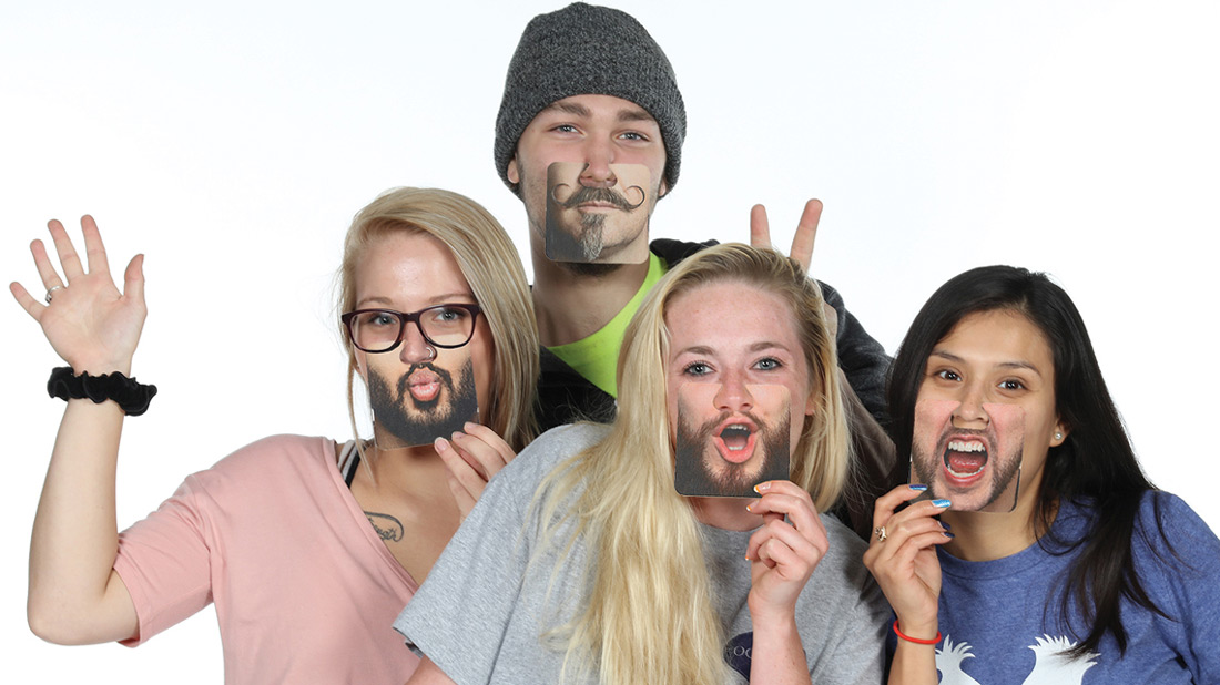 Young people wearing custom printed nose coasters with beards and mustaches. 