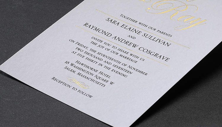 A custom wedding invitation with small design elements in gold foil. 