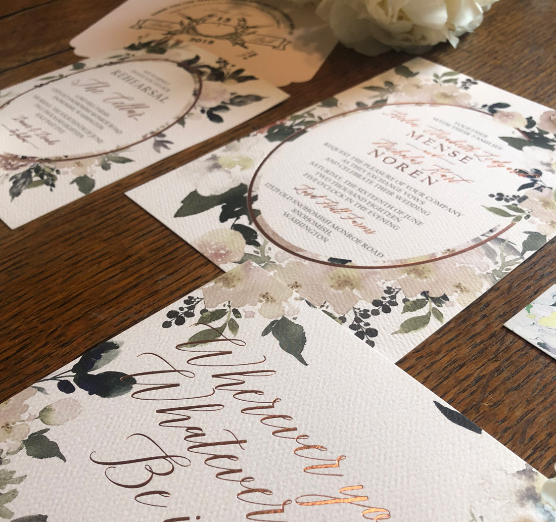 Closeup image of floral wedding invitations printed in full color digital and gold foil stamping. 
