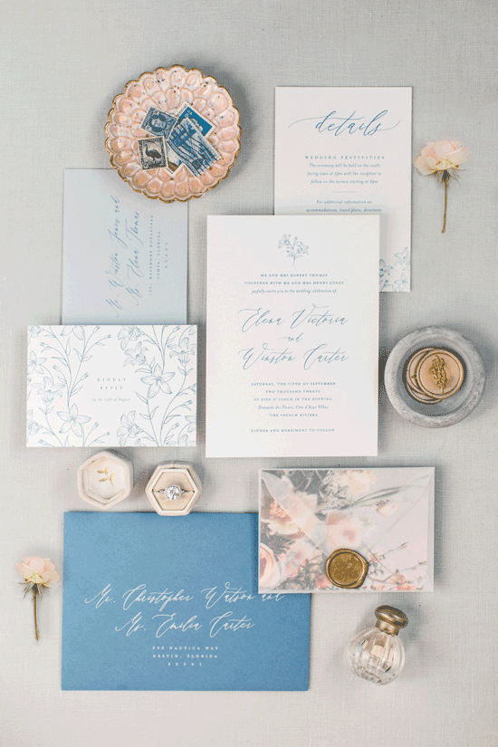 Floral-inspired wedding invitation suite with cobalt envelope and gold wax seal.