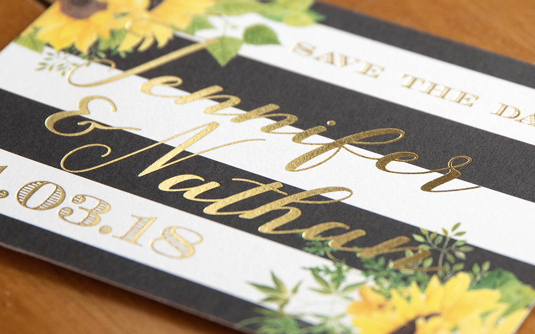 Black and white striped save the date with gold foil stamping and yellow sunflowers. 