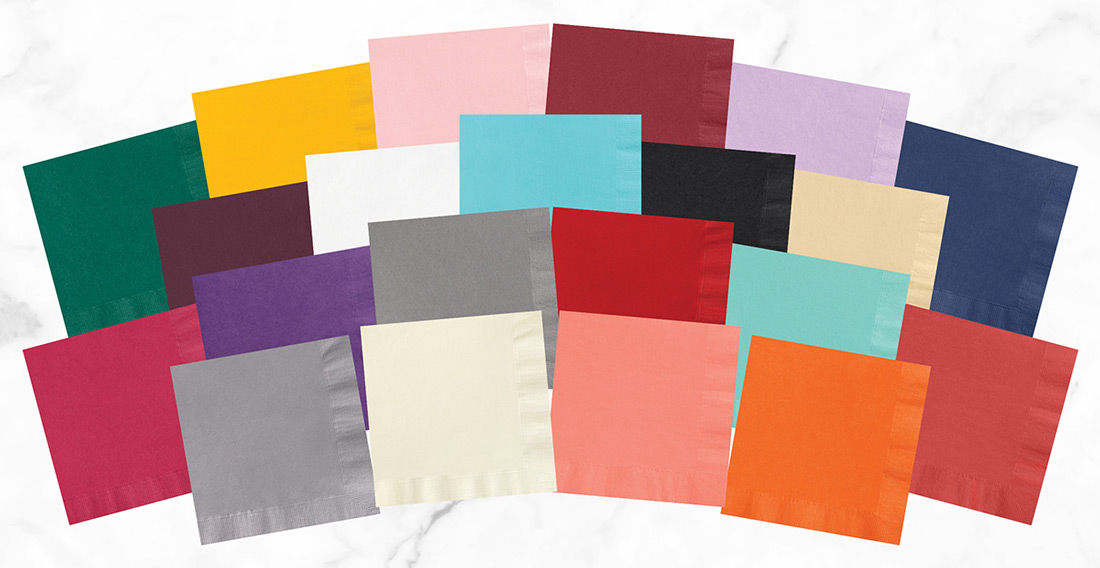 Several custom print paper napkins in a variety of colors overlapping and arranged in arches like a rainbow.
