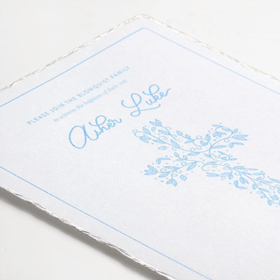 Baptism invitation with light blue thermography and a pearl foil deckle edge. 