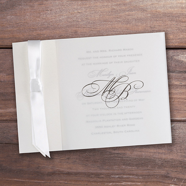 Wedding invitation with translucent vellum overlay and satin ribbon. 