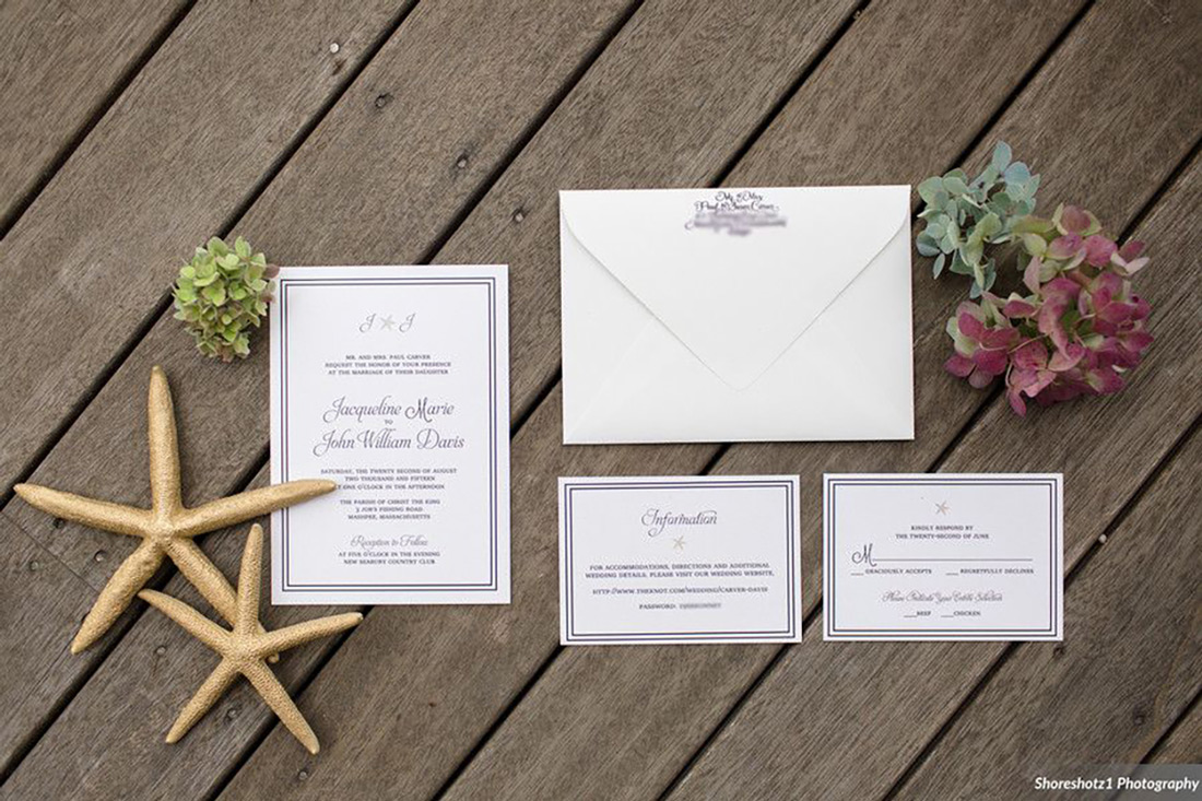 A custom wedding invitation suite with nautical theme is shown with sea treasures on a wood board background. 