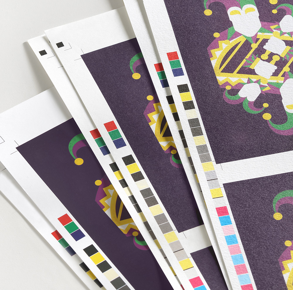 A closeup of three different papers used for the same mardi gras design when digitally printed. 