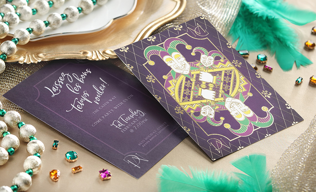 A lifestyle shot with the mardi gras invitation surrounded by jewels, pearls and feathers. 