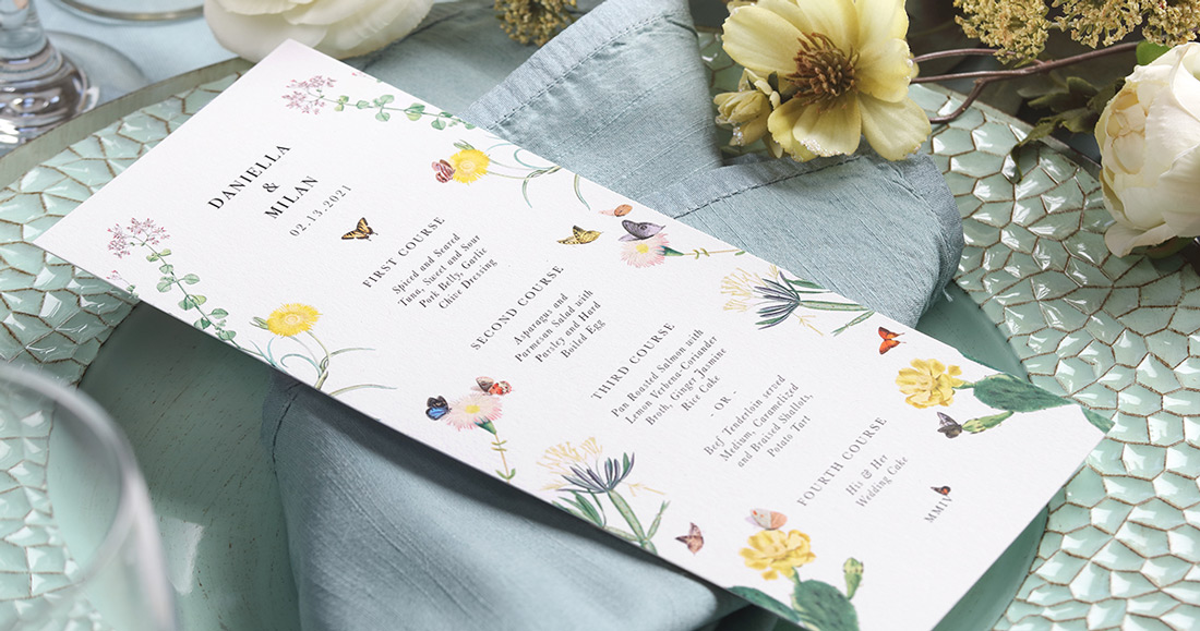 A digitally printed menu card by Xitlalli Design with full-color floral design shown on a beautiful plate setting. 