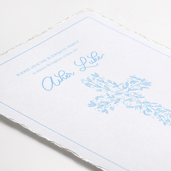 Baptism invitation with custom design in light blue thermography and a pearl deckle edge. 