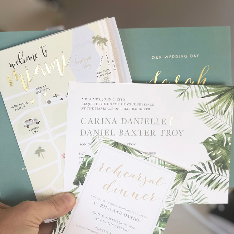 A destination wedding invitation suite designed by Gina P. with tropical greenery designs. 