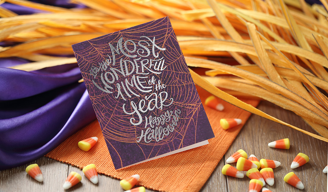 A purple card with orange spiderweb and "the most wonderful time of the year" stamped in silver foil. 