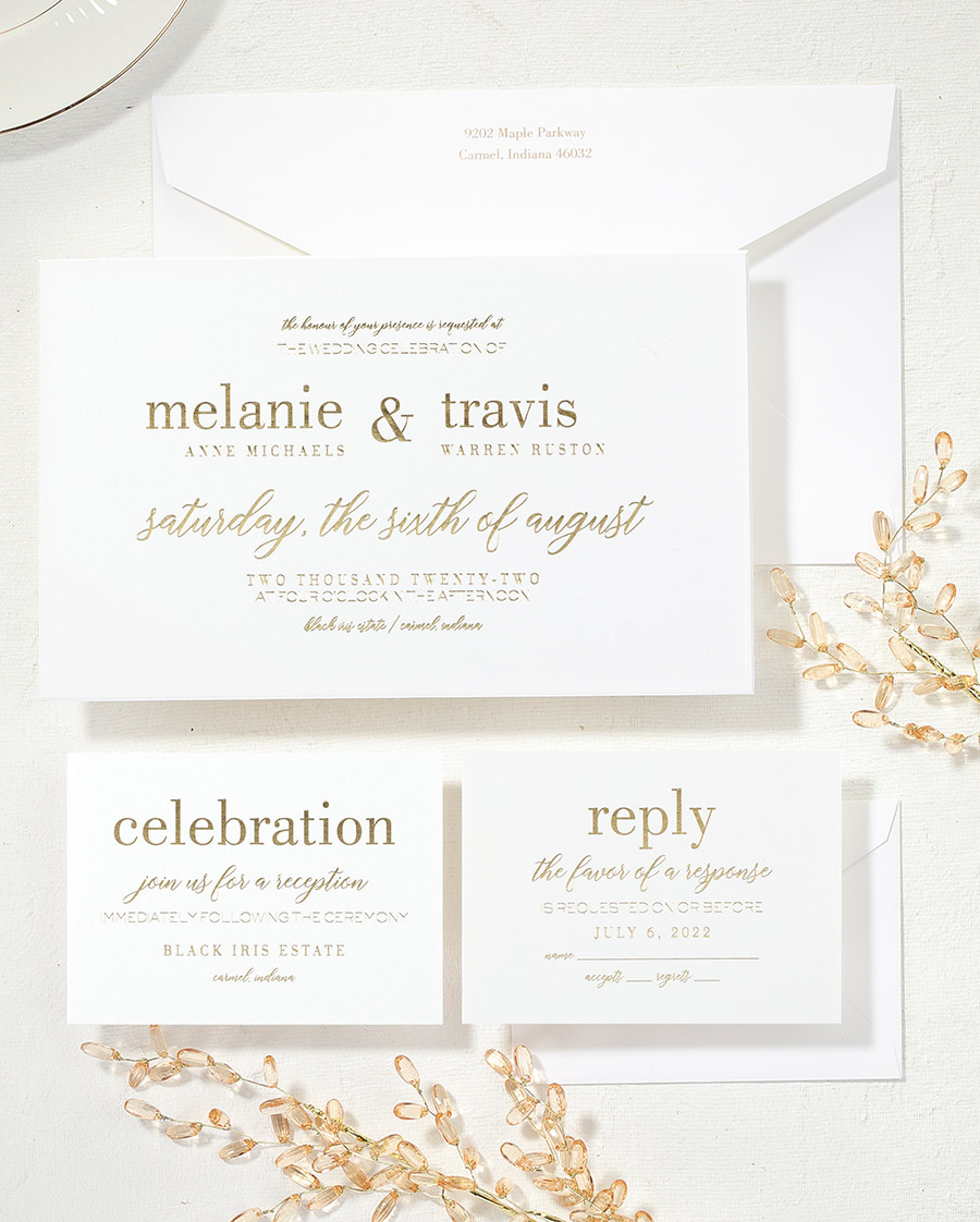 An elegant custom wedding invitation suite is shown with gold foil stamping and sparkling accents. 