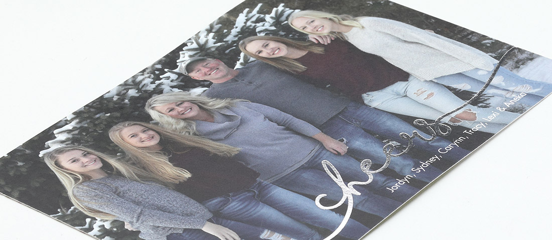 A photo holiday card is shown with "cheers" stamped in silver foil along the bottom. 