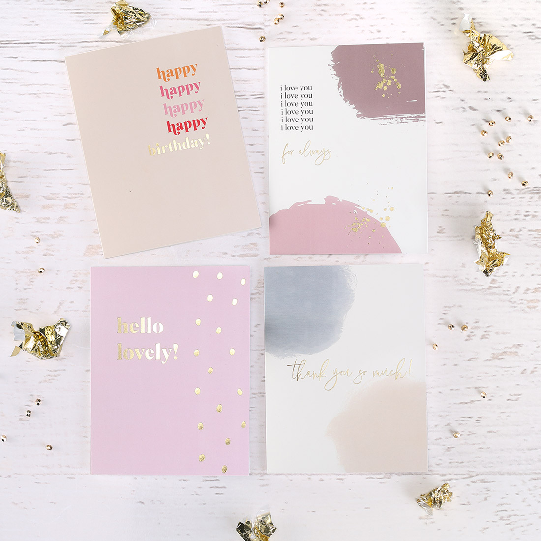 Modern and colorful greeting cards with gold foil are shown next to each other with crumpled gold foil decorations.