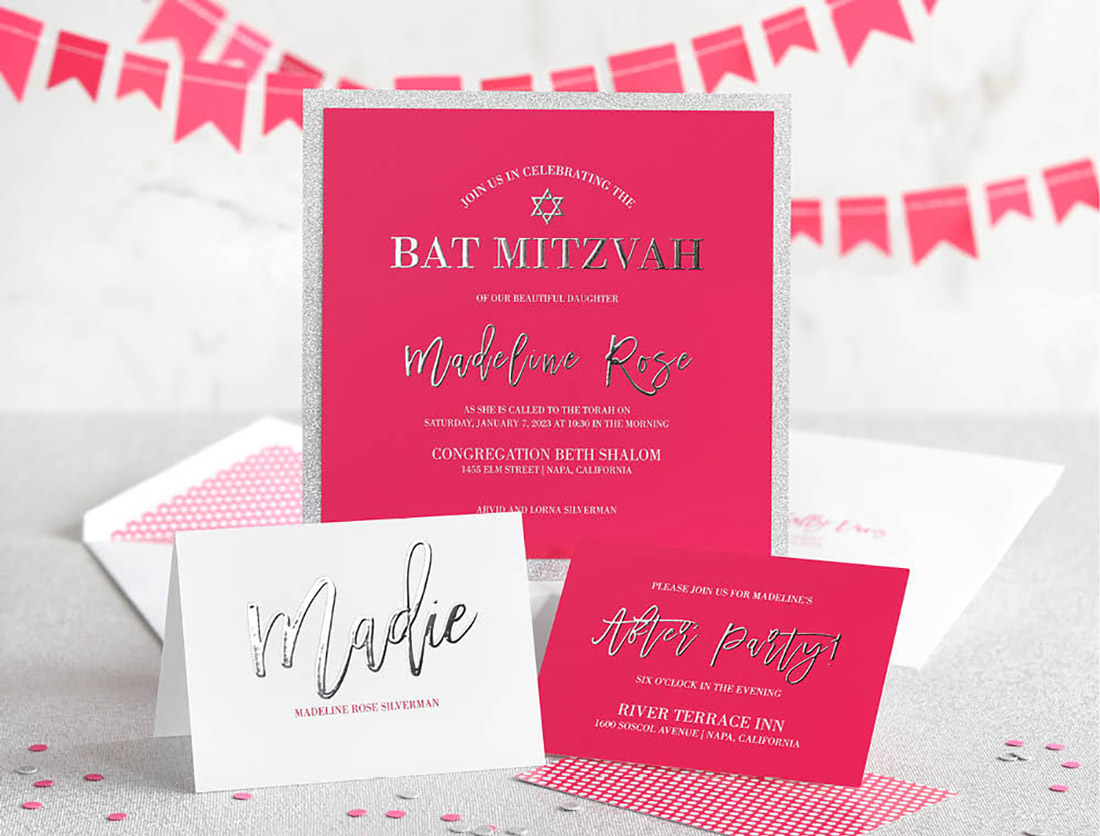 A bright and beautiful Bat Mitzvah Invitation suite with silver enhanced foil is shown with party decorations in the background. 