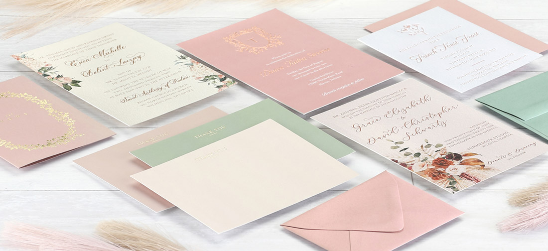 A collage of different custom invitation designs in muted colors displayed elegantly next to each other. 