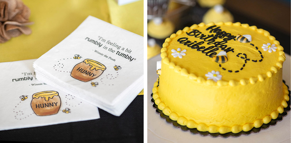 Custom beverage napkins featuring honey pot design and Winnie the Pooh quote are shown next to a bright yellow cake. 