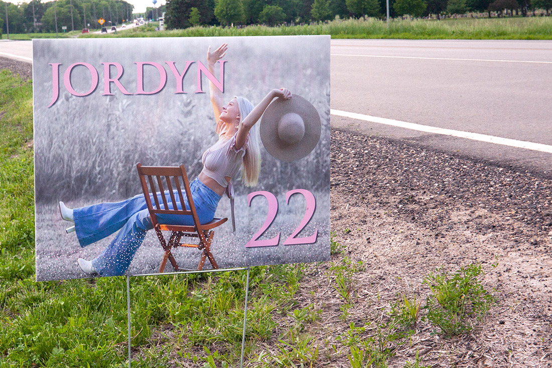 A yard sign featuring a photo of the graduate marks where to turn for the party. 
