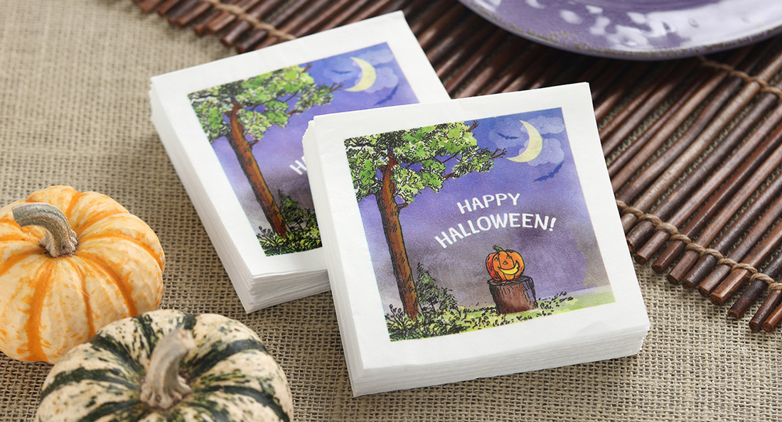 Beverage napkins digitally printed with a pumpkin in the forefront of a purple evening sky.