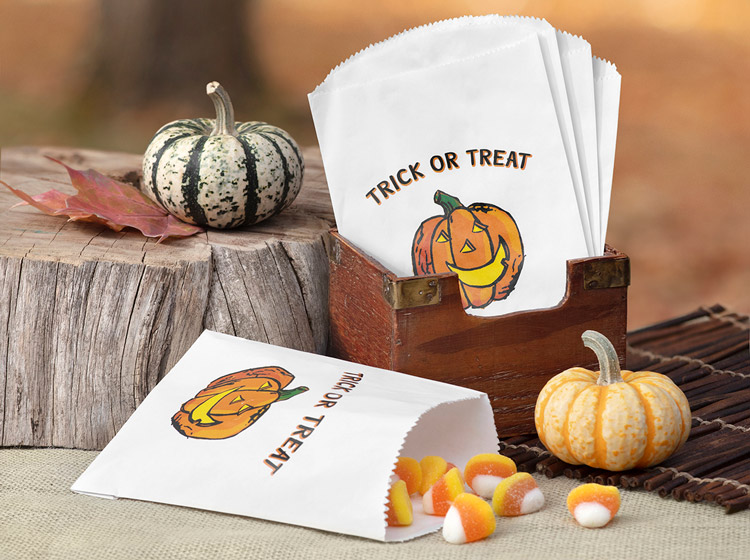 A happy Jack 'O Lantern is printed in full color on white treat bags and displayed with pumpkin accents.