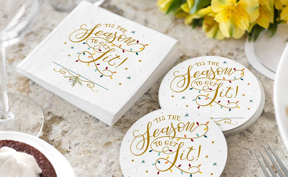 Beverage napkins and coasters shown with the phrase "Tis the season to get lit" and holiday lights. 