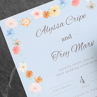 Bright colorful flowers on a sky blue wedding invitation.